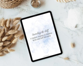 May include: A digital tablet displaying a blue and white watercolor background with the text "Unveiling the Self: A Guided Journey of Shadow Work and Self-Discovery".