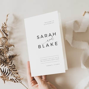 Könnte beinhalten: Ein weißes Hochzeitsprogramm mit schwarzem Text. Das Programm lautet "Willkommen zu unserer Hochzeit" und listet die Namen "Sarah und Blake" auf. Das Datum ist mit "Samstag, 25. August Zwei tausend und zwanzig XXXX" angegeben und der Ort ist "Toronto, Ontario."