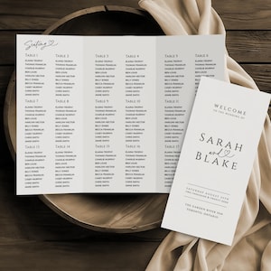 May include: A wedding seating chart and welcome sign. The seating chart lists names under table numbers. The welcome sign says "Welcome to the Wedding of Sarah and Blake" with the date and location.