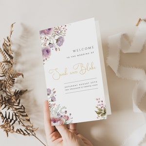 May include: A wedding program with a floral design featuring purple and pink flowers. The text reads "Welcome to the wedding of Sarah and Blake, Saturday August 25th, two thousand and twenty xxxx".
