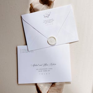 Puede incluir: Dos sobres blancos con un sello de cera en el sobre superior. El sobre superior tiene el texto "ELOUISE & BLAKE 125 GREENERY LANE NEW YORK NY 70141". El sobre inferior tiene el texto "Michael and Lillian Roberts 125 GREENERY LANE NEW YORK NY 70143".
