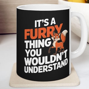 Puede incluir: Taza de cerámica blanca con fondo negro y un zorro de dibujos animados. La taza tiene el texto "It's a furry thing you wouldn't understand".