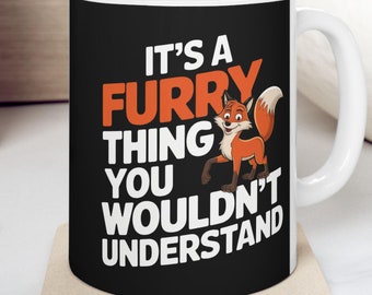 May include: White ceramic mug with a black background and a cartoon fox. The mug has the text "It's a furry thing you wouldn't understand".