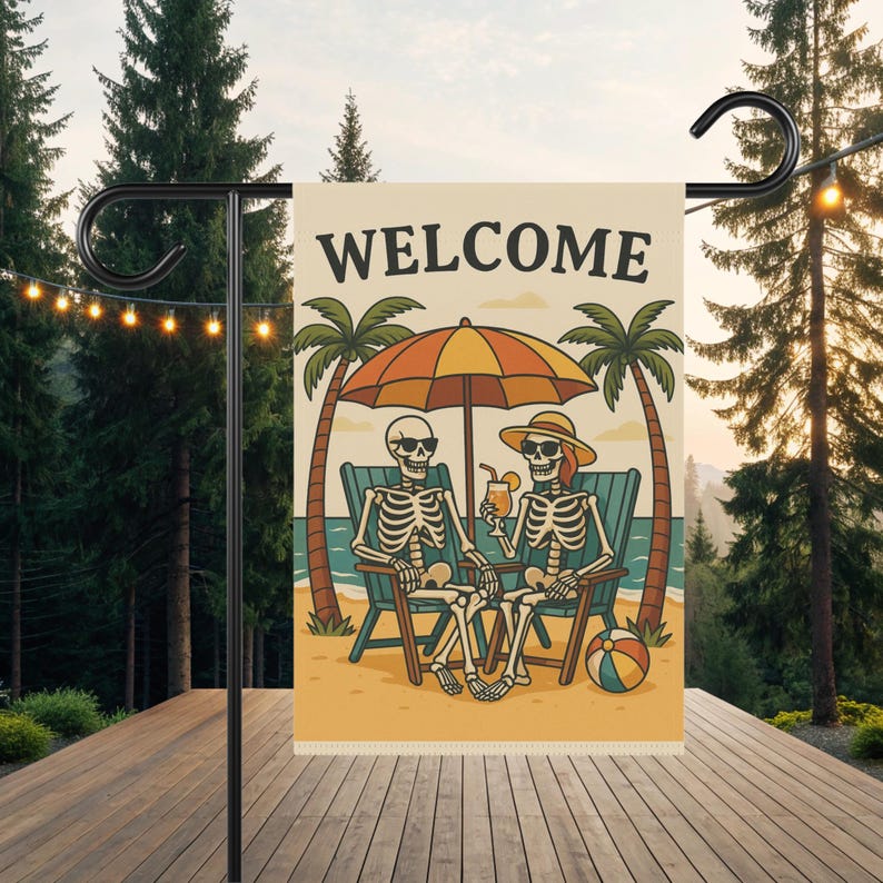 May include: A garden flag with the word "WELCOME" in large letters. The flag features a cartoon illustration of two skeletons relaxing on a beach under an umbrella, with palm trees and a beach ball.