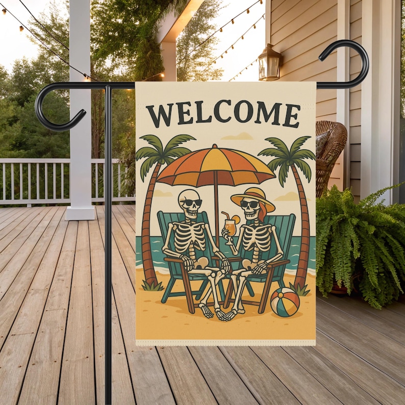Skeleton Garden Flag showing two skeletons lounging under a beach umbrella on a sandy shore with palm trees—ideal as a Summer Skeleton Flag, Spooky Garden Flag, Halloween Garden Flag, and Beach Skeleton Flag.