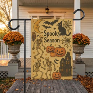 12×18″ double-sided vintage Halloween garden flag with mustard-tone background and retro spooky season design featuring dancing skeletons, carved jack-o’lanterns, a haunted house silhouette, bats, a black cat, spider webs, an owl and crescent moon—perfect for a spooky garden flag