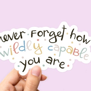 May include: A sticker with the text "never forget how wildly capable you are." The text is written in a whimsical font with colorful accents.