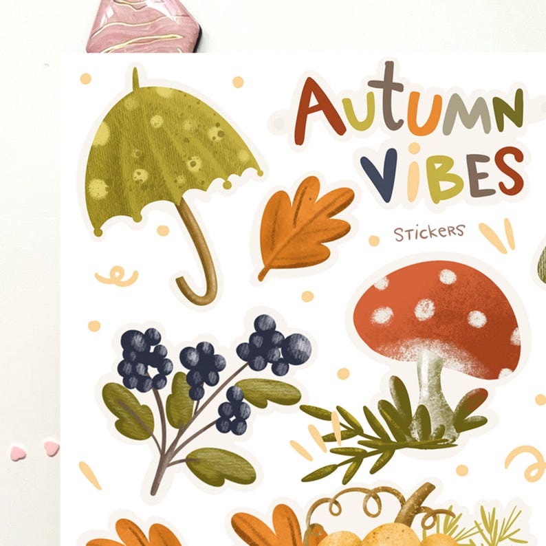 K&ouml;nnte beinhalten: Ein Set mit Herbst-Stickern, darunter ein gr&uuml;ner Regenschirm, ein rot-wei&szlig;er Pilz, ein braunes Blatt, ein Zweig mit gr&uuml;nen Bl&auml;ttern und schwarzen Beeren sowie der Text "Autumn Vibes Stickers".