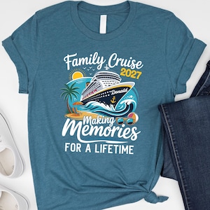 May include: A teal blue short-sleeve t-shirt featuring a graphic of a cruise ship on ocean waves, a palm tree, a beach chair, and sunglasses. The text reads Family Cruise 2027, Donald, Making Memories, and FOR A LIFETIME in white and yellow.