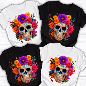 May include: Four short-sleeve t-shirts in black and white, each featuring a central graphic of a sugar skull adorned with vibrant, multi-colored flowers including purple, orange, red, and blue blossoms surrounding the skull.