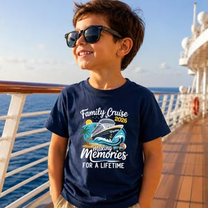 May include: A navy blue short-sleeved t-shirt featuring a graphic print of a cruise ship on ocean waves with palm trees, a sun, and the text Family Cruise 2026 Making Memories For A Lifetime with the name Kayden on the ship hull.