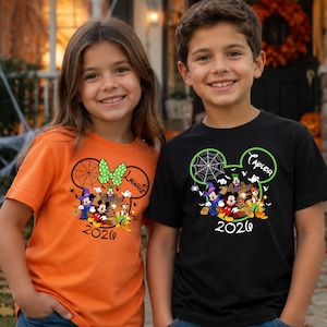 May include: An orange t-shirt and a black t-shirt, each featuring a graphic of Disney characters in Halloween costumes inside a Mickey Mouse ear silhouette, a spider web, the name Laurie or Taylor, and the year 2026 printed in black text.