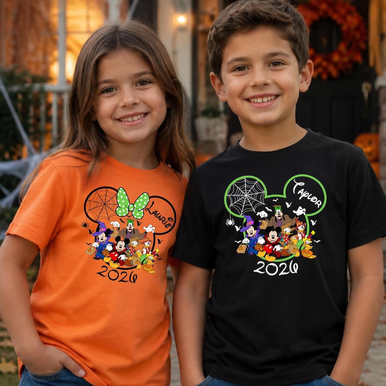 May include: An orange t-shirt and a black t-shirt, each featuring a graphic of Disney characters in Halloween costumes inside a Mickey Mouse ear silhouette, a spider web, the name Laurie or Taylor, and the year 2026 printed in black text.