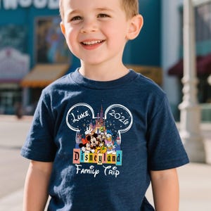 Puede incluir: Camiseta azul marino con un colorido dise&ntilde;o de Disneyland con Mickey Mouse, Minnie Mouse, Donald Duck y Goofy. La camiseta incluye el texto "Luke 2020" y "Disneyland Family Trip".