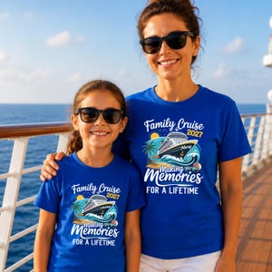 May include: Two royal blue t-shirts featuring a graphic of a cruise ship on ocean waves, a palm tree, and a sun. The text reads Family Cruise 2027 Making Memories FOR A LIFETIME. The shirts have short sleeves and a crew neckline.