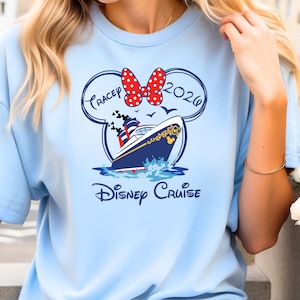 May include: Light blue t-shirt featuring a Disney Cruise design. The design includes a cruise ship, a Minnie Mouse bow, and the text "Tracey 2026" inside a Mickey Mouse head outline, with the words "Disney Cruise" below.
