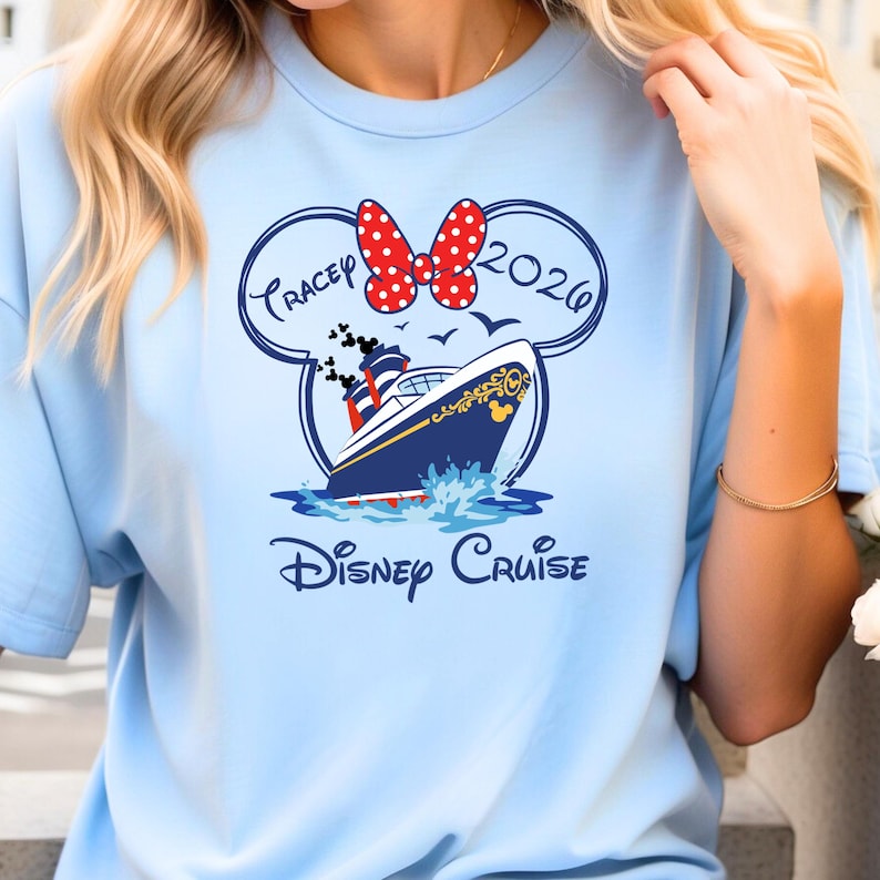 May include: Light blue t-shirt featuring a Disney Cruise design. The design includes a cruise ship, a Minnie Mouse bow, and the text "Tracey 2026" inside a Mickey Mouse head outline, with the words "Disney Cruise" below.