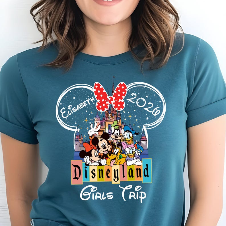 Puede incluir: Camiseta de color verde azulado con un dise&ntilde;o de Disneyland. El dise&ntilde;o incluye a Mickey y Minnie Mouse, Goofy, Donald y Daisy Duck, y un castillo. El texto dice "Elisabeth 2020" y "Disneyland Girls Trip."