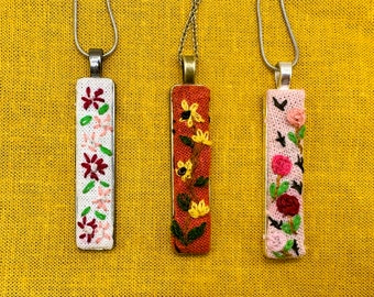 Hand embroidered floral pendants.