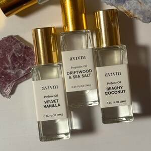 May include: Three perfume oil bottles with gold lids and white labels. The labels read "Velvet Vanilla", "Driftwood & Sea Salt", and "Beachy Coconut". Each bottle contains 7ml of perfume oil.