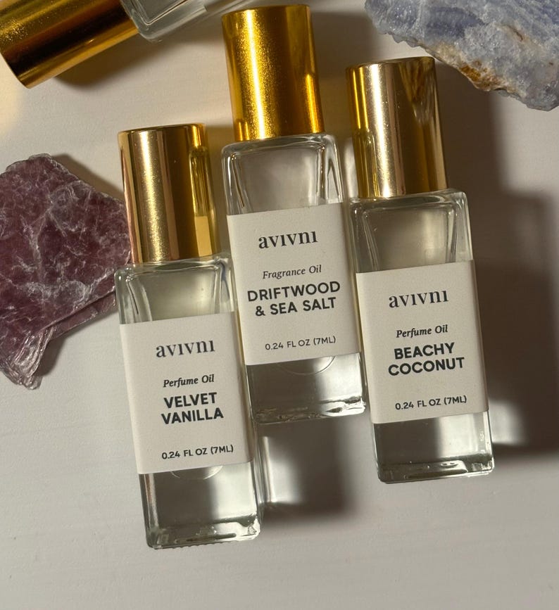 May include: Three perfume oil bottles with gold lids and white labels. The labels read "Velvet Vanilla", "Driftwood & Sea Salt", and "Beachy Coconut". Each bottle contains 7ml of perfume oil.