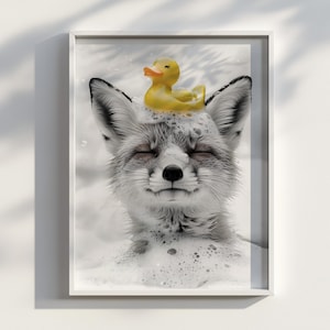 Puede incluir: Una impresión en blanco y negro enmarcada de un zorro en un baño de burbujas, con un patito de goma amarillo en la cabeza. El zorro tiene los ojos cerrados y parece relajado. La impresión está en un marco blanco.