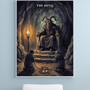 May include: A framed wall art print depicting The Devil tarot card. A horned goat-like figure sits on a stone throne inside a dark cave, illuminated by a torch. Two hooded figures kneel in front, chained together. The Roman numeral XV is visible.