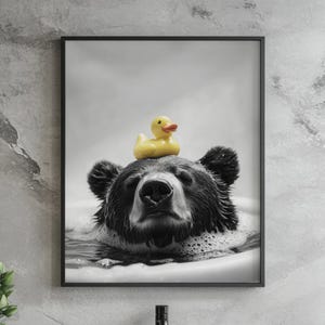 May include: A black and white photo of a bear with a yellow rubber ducky on its head. The bear is in a bathtub filled with bubbles.