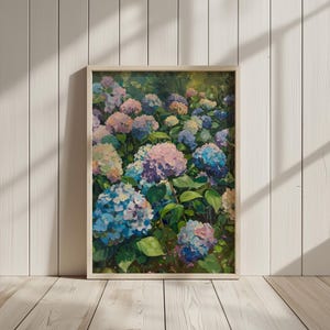 以下が含まれることがあります： 青、紫、ピンクの色合いのアジサイの群れを描いた額装された絵画。花は緑豊かな庭園に配置されています。