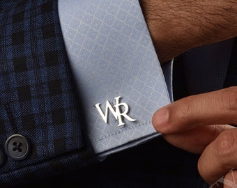 May include: A pair of silver cufflinks with the initials "WR" engraved on them. The cufflinks are being worn by a person wearing a blue plaid suit and a light blue dress shirt.