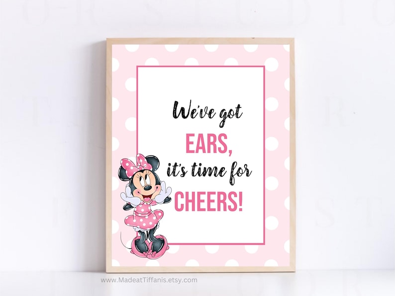 May include: A pink and white polka dot sign with a cartoon image of Minnie Mouse. The sign says "We've got ears, it's time for cheers!"