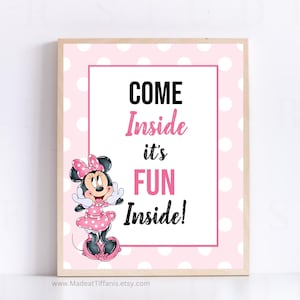 May include: Pink and white polka dot sign with a cartoon image of Minnie Mouse. The sign says "Come Inside it's Fun Inside!"