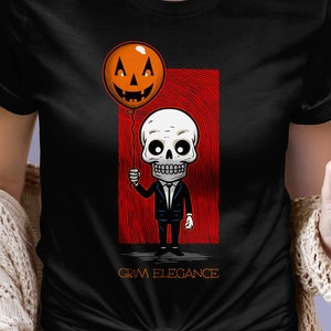 Grim Elegance t-shirt featuring a dapper wood cut style skeleton wearing a suit and holding a smiling orange jack-o&#39;-lantern balloon