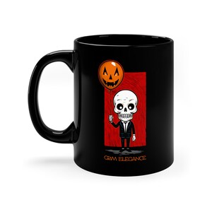 May include: Black ceramic mug with a white skeleton wearing a tuxedo holding a jack-o-lantern balloon. The mug has the text "Grim Elegance" printed on the bottom.