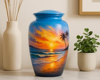 Könnte beinhalten: Eine blaue Urne mit einer gemalten Sonnenuntergangs-Strandszene. Die Urne zeigt einen lebendigen Sonnenuntergang über dem Meer mit Palmen. Die Urne ist zylindrisch mit einem passenden blauen Deckel. Die Urne wird auf einer weißen Oberfläche ausgestellt.
