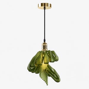 May include: A pendant light fixture featuring a gold-toned ceiling canopy and socket, suspended by a black cord. The shade consists of multiple curved, translucent olive-green glass elements arranged in a layered, cascading, fan-like formation.
