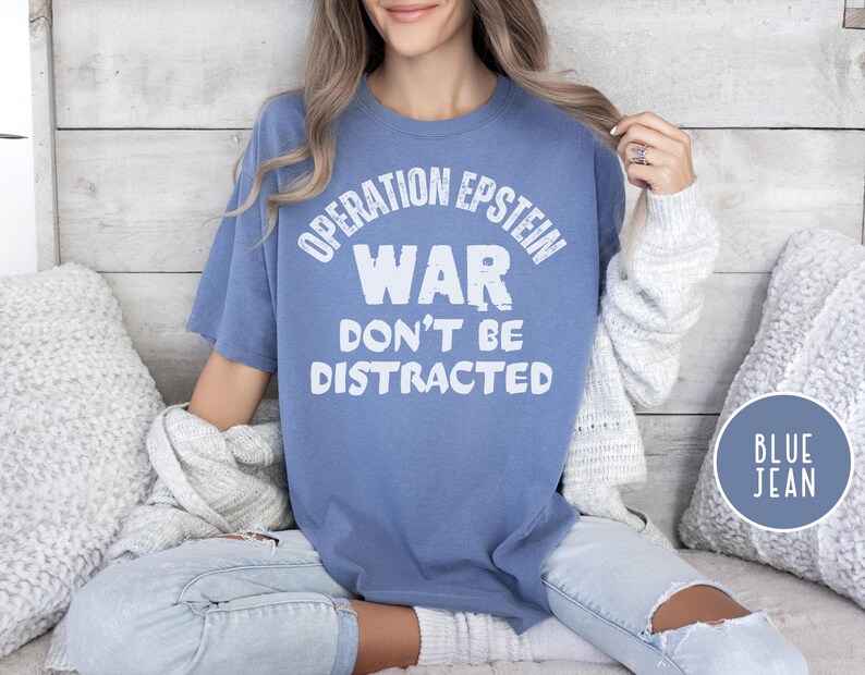 Anti War with Iran Operation Epstein Don't be Distracted. This garment speaks with conviction. A heavyweight, garment-dyed tee printed with a bold, protest-forward message that draws attention without shouting. The soft, broken-in hand of garment dyeing and the relaxed fit make it comfortable for long days at rallies, vigils, or standing on the street holding a sign. Worn by someone who wants their stance to be seen and felt, it layers easily under a jacket or stands alone as a statement piece.