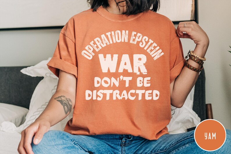 Anti War with Iran Operation Epstein Don't be Distracted. This garment speaks with conviction. A heavyweight, garment-dyed tee printed with a bold, protest-forward message that draws attention without shouting. The soft, broken-in hand of garment dyeing and the relaxed fit make it comfortable for long days at rallies, vigils, or standing on the street holding a sign. Worn by someone who wants their stance to be seen and felt, it layers easily under a jacket or stands alone as a statement piece.