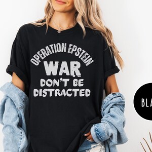 Anti War with Iran Operation Epstein Don't be Distracted. This garment speaks with conviction. A heavyweight, garment-dyed tee printed with a bold, protest-forward message that draws attention without shouting. The soft, broken-in hand of garment dyeing and the relaxed fit make it comfortable for long days at rallies, vigils, or standing on the street holding a sign. Worn by someone who wants their stance to be seen and felt, it layers easily under a jacket or stands alone as a statement piece.