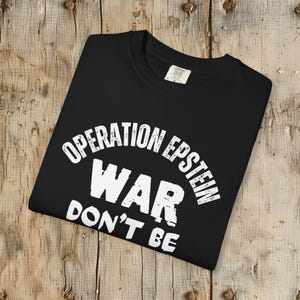 Anti War with Iran Operation Epstein Don't be Distracted. This garment speaks with conviction. A heavyweight, garment-dyed tee printed with a bold, protest-forward message that draws attention without shouting. The soft, broken-in hand of garment dyeing and the relaxed fit make it comfortable for long days at rallies, vigils, or standing on the street holding a sign. Worn by someone who wants their stance to be seen and felt, it layers easily under a jacket or stands alone as a statement piece.