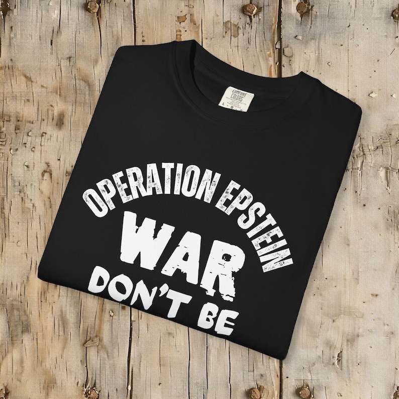 Anti War with Iran Operation Epstein Don't be Distracted. This garment speaks with conviction. A heavyweight, garment-dyed tee printed with a bold, protest-forward message that draws attention without shouting. The soft, broken-in hand of garment dyeing and the relaxed fit make it comfortable for long days at rallies, vigils, or standing on the street holding a sign. Worn by someone who wants their stance to be seen and felt, it layers easily under a jacket or stands alone as a statement piece.