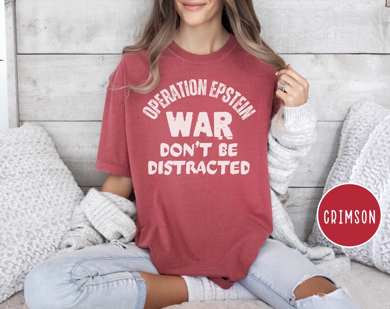Anti War with Iran Operation Epstein Don't be Distracted. This garment speaks with conviction. A heavyweight, garment-dyed tee printed with a bold, protest-forward message that draws attention without shouting. The soft, broken-in hand of garment dyeing and the relaxed fit make it comfortable for long days at rallies, vigils, or standing on the street holding a sign. Worn by someone who wants their stance to be seen and felt, it layers easily under a jacket or stands alone as a statement piece.