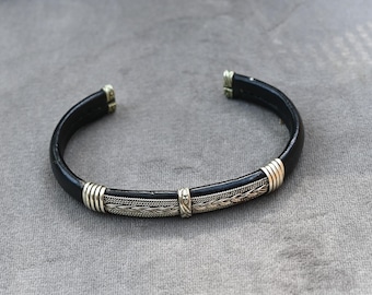 Bracciale rigido unico in pelle e argento sterling, realizzato da nativi americani. Lunghezza indossabile: da 6 1/2 a 7 1/2 pollici (da 16,5 a 19 cm circa). Peso: 20,4 grammi.