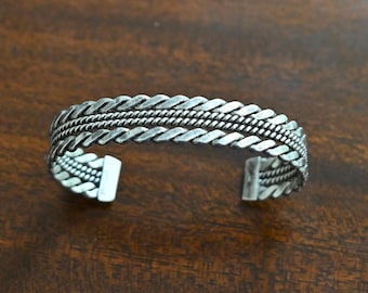 Bracciale rigido Navajo Tahe firmato, in argento sterling con lavorazione a corda, 22,4 grammi, lunghezza 7 pollici (circa 17,8 cm) con apertura. Bracciale rigido Navajo Tribe Tahe, largo 1/2 pollice (circa 1,27 cm).
