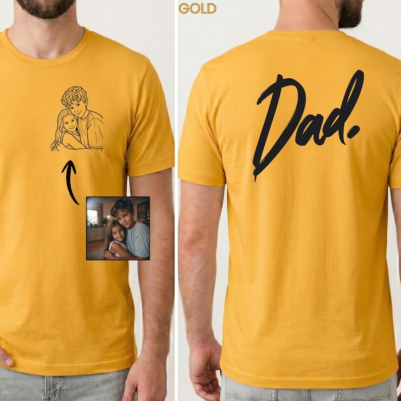 May include: A mustard yellow t-shirt featuring a black line art illustration of a person hugging a child on the front left chest. The back of the shirt displays the word Dad in a large black script font. A small photo reference is included.