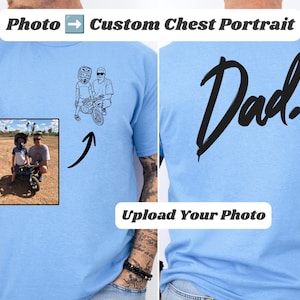 May include: A light blue t-shirt featuring a custom black line art illustration on the chest, derived from a photograph of a person and a child on a bicycle. The back of the shirt displays the word Dad in a large, bold, black script font.