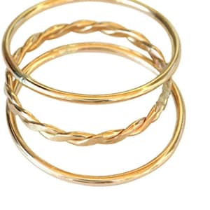 May include: A set of three gold rings, one with a twisted design and two plain bands.