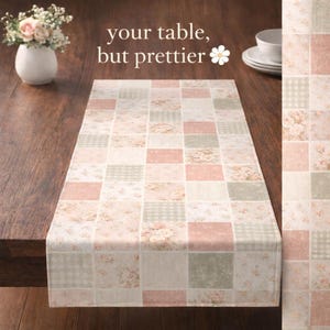 Peut inclure: Chemin de table rectangulaire avec un motif patchwork. Il présente des carrés à motifs floraux, vichy et unis dans des tons rose, vert et crème. Le texte "your table, but prettier" est visible.