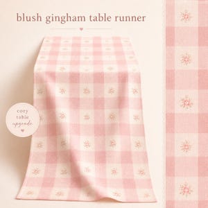 Peut inclure: Chemin de table en vichy rose et blanc avec un motif floral. Le texte "blush gingham table runner" est en haut. Le texte "cozy table upgrade" est sur une étiquette circulaire. Tissu doux.