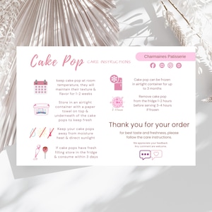May include: A pink and white card with "Cake Pop" in cursive and care instructions. The card includes icons and text about storing cake pops, including keeping them at room temperature, in an airtight container, and away from heat.